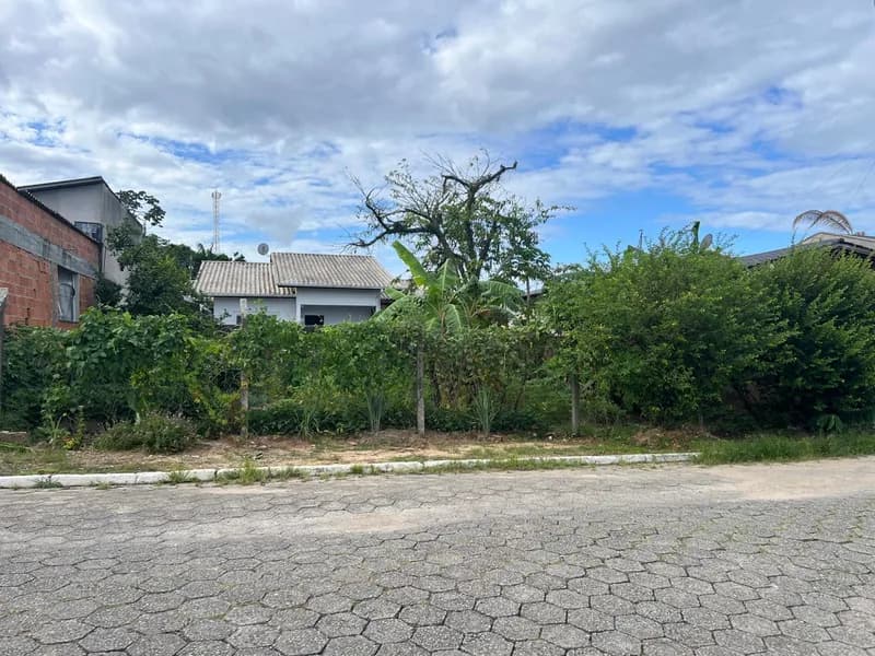 Terreno com vegetação exuberante e casa ao fundo em Santo Antônio, Balneário Piçarras/SC